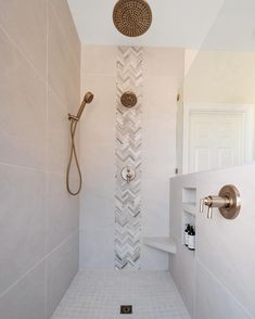 a bathroom with a shower head, toilet and tiled walls in the shower stall area