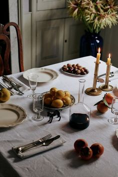 the table is set with plates, silverware and candles