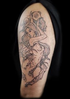 a woman's arm with a tattoo on it that has an image of a mermaid