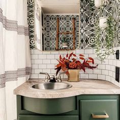 a bathroom sink sitting under a mirror next to a green cabinet and white shower curtain