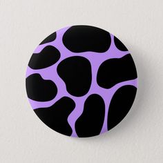 a black and purple button with an animal print pattern on the front, sitting on a white surface