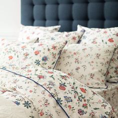 an image of a bed with floral comforter and pillow cases on top of it