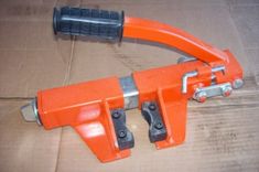 an orange plastic clamper sitting on top of a cardboard box