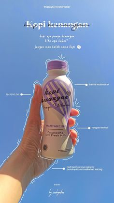 a hand holding a bottle of yogurt in front of a blue sky with information about it