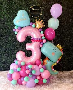 a birthday cake with balloons and animals on it, including the number three surrounded by other decorations