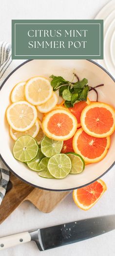 citrus mint summer pot with sliced oranges and limes in it on a cutting board