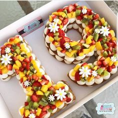 a number made out of fruit and decorated with flowers in the shape of the letter o