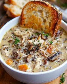 a close up of a bowl of soup with bread