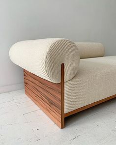 a white couch sitting on top of a wooden frame