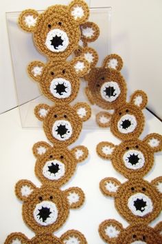 several crocheted teddy bears sitting next to each other in front of a clear box