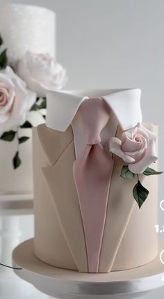 there is a wedding cake decorated with flowers and a tuxedo on the top