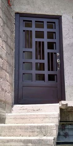 a cat sitting on the steps in front of a door