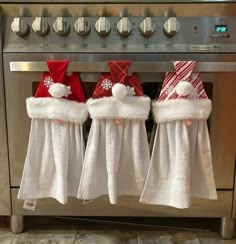 three christmas towels hanging on the oven door