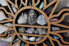 a wooden clock with crystals and rocks in it's center wheel on the wall