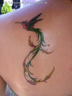 the back of a woman's shoulder with a bird tattoo on it