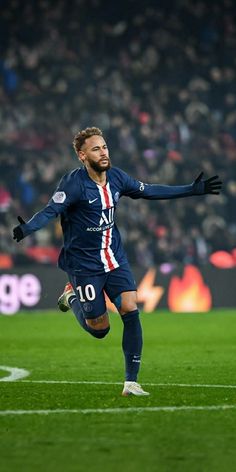 a soccer player is running on the field with his arms out to catch the ball