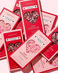 six packets of chocolate with pink and red sprinkles in the shape of a heart