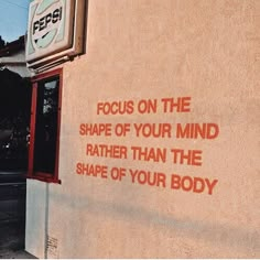 a sign on the side of a building that says focus on the shape of your mind rather than the shape of your body