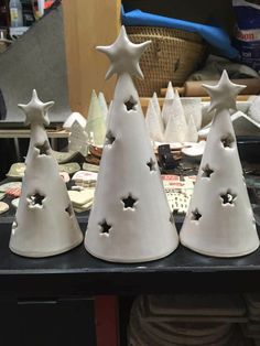 three white ceramic christmas trees sitting on top of a table