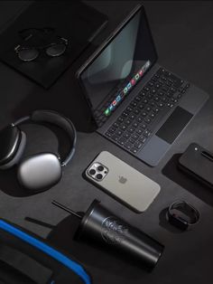 an apple laptop computer sitting on top of a table next to headphones and other accessories