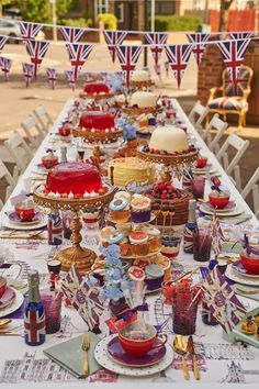 a long table covered in lots of cakes and cupcakes on top of plates