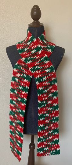 a red, green and white knitted scarf on a mannequin