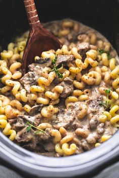 the crock pot is filled with macaroni and cheese, meat and parsley