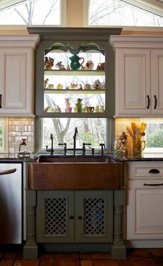 a kitchen with white cabinets and an old fashioned copper sink in front of a window