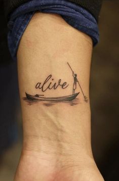 a person with a small tattoo on their wrist that reads alive and is holding a fishing pole