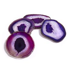 three slices of purple agate with white and black veining on the edges, sitting next to each other