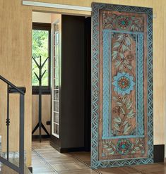 an ornate wooden door is open on the floor in front of a doorway with glass doors