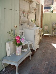 there is a room with white furniture and pink flowers in vases on the table