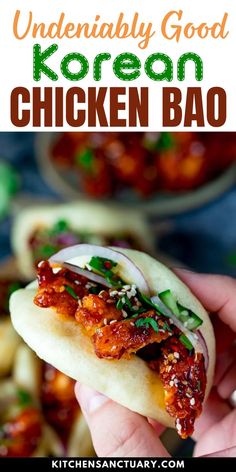 a hand holding up a chicken bao with sauce and onions on it, in front of other