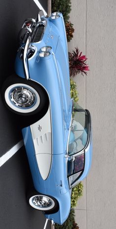 an overhead view of a blue car parked on the side of the road with its hood up