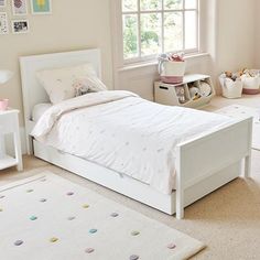 a child's bedroom with white furniture and decor