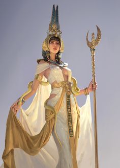 a woman dressed as an egyptian goddess holding a staff