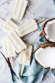 coconut milk popsicles on a blue napkin with two pieces cut out and one half eaten