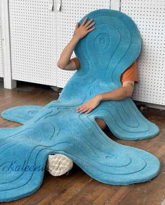 a person laying on top of a blue rug in the shape of a whale with its mouth open