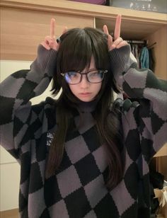 a girl with glasses making the peace sign