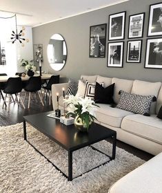 a living room filled with furniture and pictures on the wall above it's coffee table