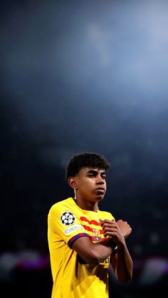 a young man standing in front of a soccer ball with his hands clasped to his chest