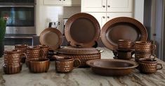 a kitchen counter topped with lots of brown dishes