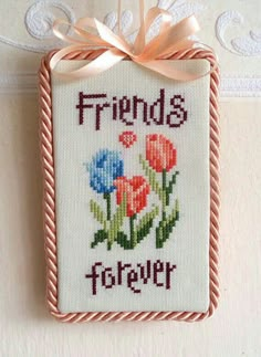 a cross stitch picture hanging on a wall with the words friends forever written in it