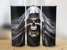 two black and white tumbles with a skull on them