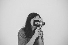 a woman holding up a camera to take a photo