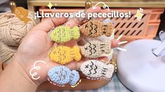 a person holding several small crocheted items in their hands, with the words laveros de pecellos written on them