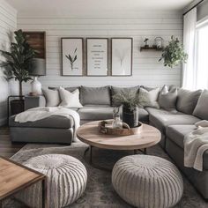 a living room filled with lots of furniture and pillows on top of a wooden floor