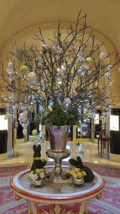 a vase filled with flowers sitting on top of a table in front of a chandelier