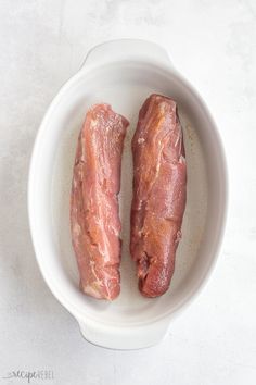 two pieces of raw meat in a white bowl