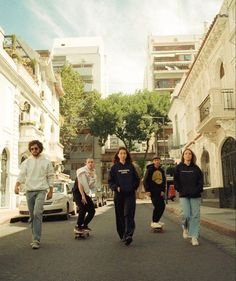 several people are skateboarding down the street